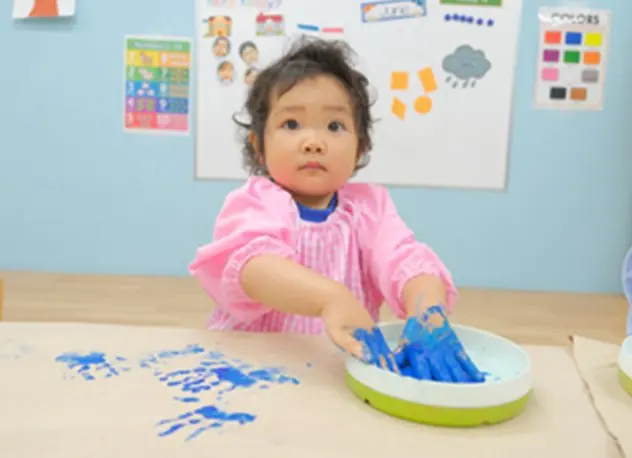 青い絵の具で手形アートに挑戦する子ども
