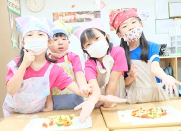 エプロン姿でピザ作りに挑戦する子どもたち
