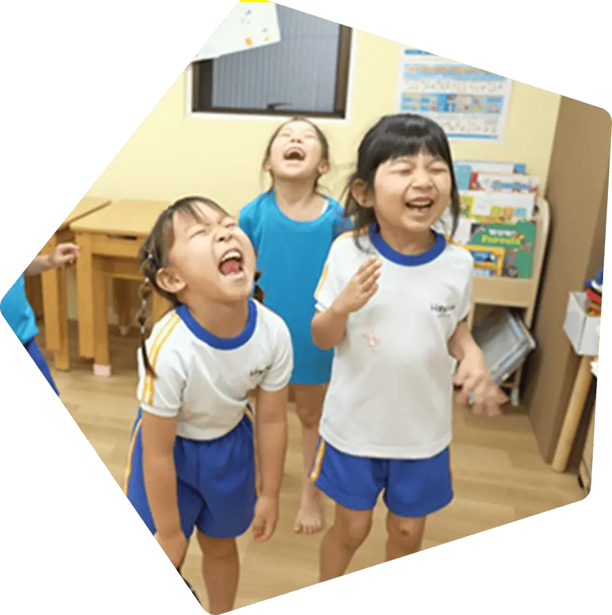 教室で笑顔いっぱいに笑い合う子どもたち